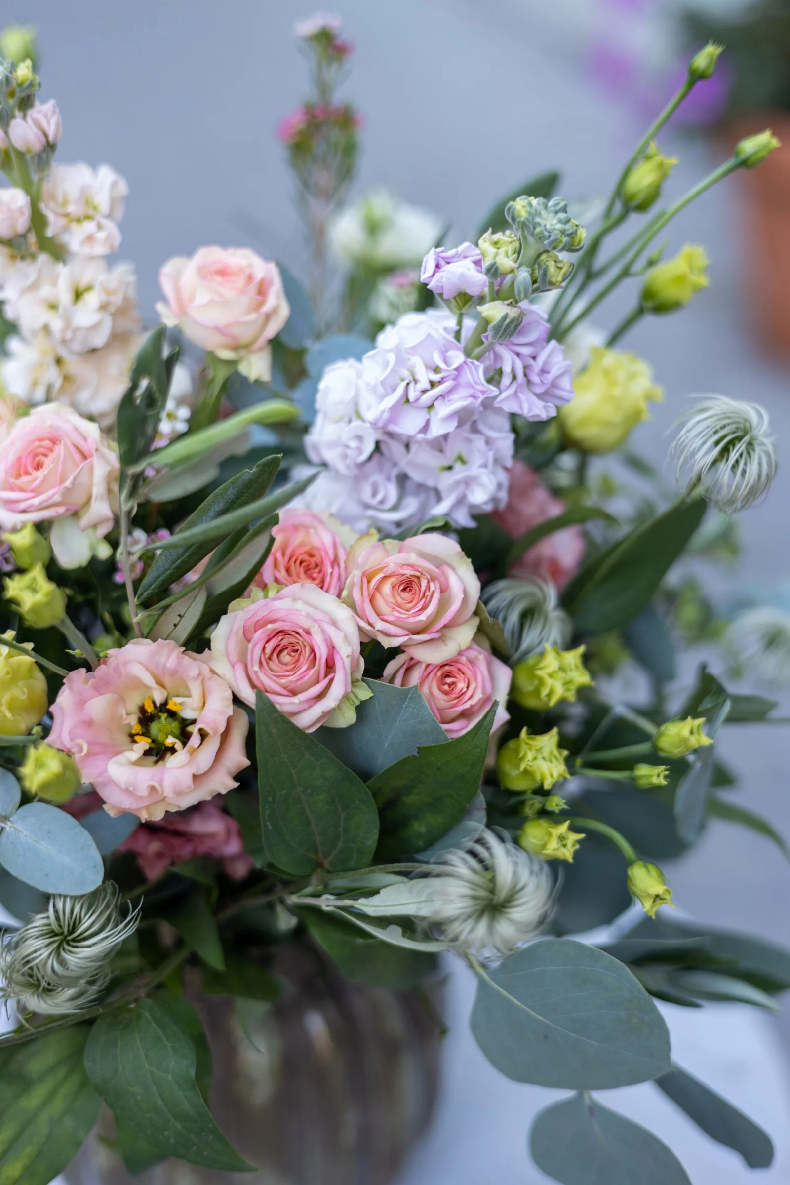 Detail pastelovej kytice — trsové ruže, levkoje, eustoma a plody plamienka